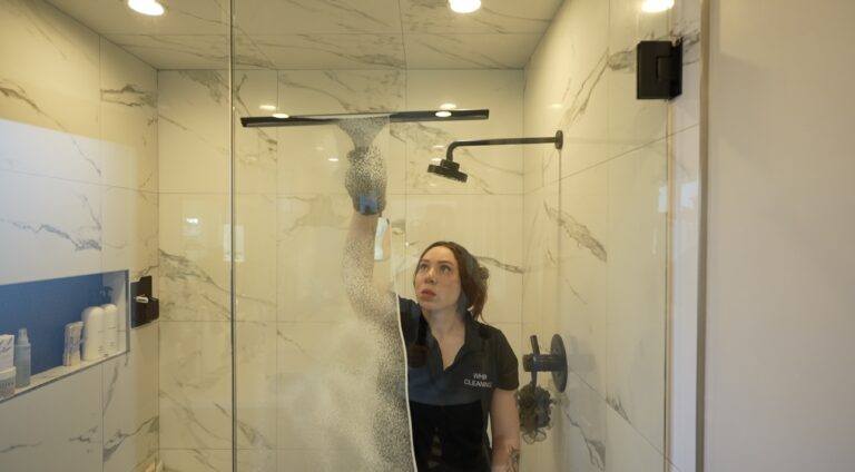 WHB Cleaning team member cleaning shower glass